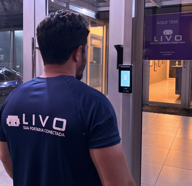 Profissional LIVO demonstrando sistema de controle de acesso na entrada do condomínio